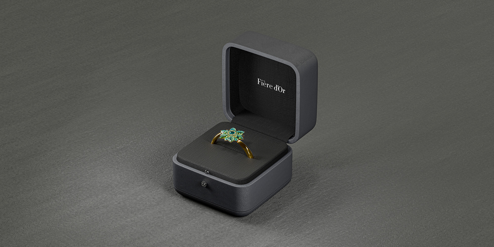 A premium gold ring with green flower-shaped gemstones inside a dark luxury box.